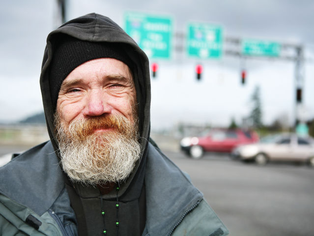 You see a homeless person on the side of the road.